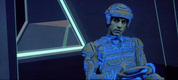 Movie still from “Tron” (1982), directed by Steven Lisberger – A man wearing a helmet and a body suit; Medium shot, High angle