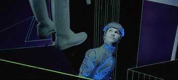 Movie still from “Tron” (1982), directed by Steven Lisberger – A man in a suit and boots in a room with neon lights; Medium shot, Low angle