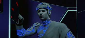 Movie still from “Tron” (1982), directed by Steven Lisberger – A man wearing a helmet and a body suit; Close Up shot, Low angle