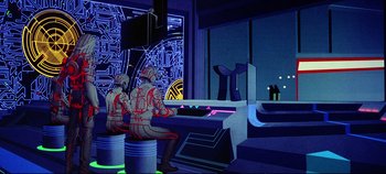 Movie still from “Tron” (1982), directed by Steven Lisberger – A group of people sitting in front of a computer screen; Wide shot, Low angle