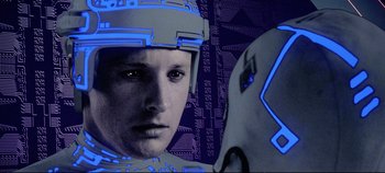 Movie still from “Tron” (1982), directed by Steven Lisberger – A man with a helmet on and another man with a helmet on; Close Up shot, Over the shoulder angle