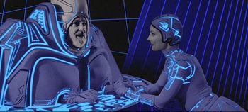 Movie still from “Tron” (1982), directed by Steven Lisberger – A man and a woman are sitting at a table; Medium shot, High angle