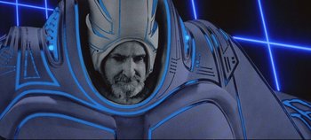 Movie still from “Tron” (1982), directed by Steven Lisberger – An old man with a beard and a helmet is in a space suit; Medium shot, Low angle