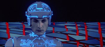 Movie still from “Tron” (1982), directed by Steven Lisberger – A man with a helmet on standing in front of a computer screen; Close Up shot, Low angle