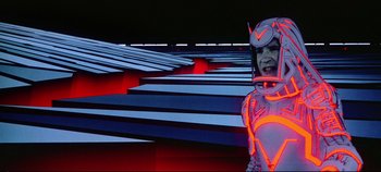Movie still from “Tron” (1982), directed by Steven Lisberger – A man in a space suit standing in front of a bunch of stairs; Medium shot, Low angle
