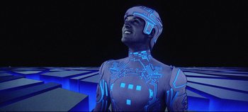 Movie still from “Tron” (1982), directed by Steven Lisberger – A man in a blue suit is standing in front of some stairs; Medium shot, Overhead angle