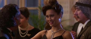 Movie still from “True Lies” (1994), directed by James Cameron – A woman in a black dress with a diamond necklace; Close Up shot, Over the shoulder angle