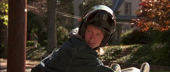 Movie still from “True Lies” (1994), directed by James Cameron – A person wearing a helmet and riding a motorcycle; Close Up shot, Low angle