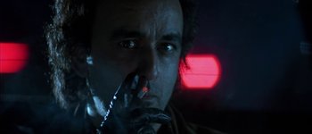 Movie still from “True Lies” (1994), directed by James Cameron – A person wearing a glove with a red light in the background; Close Up shot, Low angle