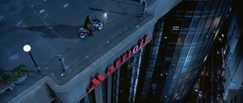 Movie still from “True Lies” (1994), directed by James Cameron – A man sitting on top of a building on top of a motorcycle; Extreme Wide shot, High angle