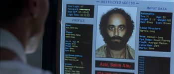 Movie still from “True Lies” (1994), directed by James Cameron – A computer screen showing a man's face and a name; Extreme Close Up shot, Overhead angle