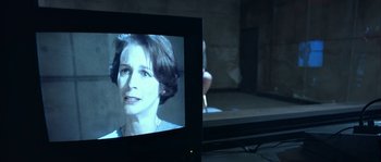 Movie still from “True Lies” (1994), directed by James Cameron – A television screen showing a woman's face on a stage; Close Up shot, Over the shoulder angle