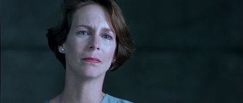 Movie still from “True Lies” (1994), directed by James Cameron – A person with short brown hair; Close Up shot, Over the shoulder angle