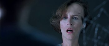 Movie still from “True Lies” (1994), directed by James Cameron – A person with short brown hair; Close Up shot, Over the shoulder angle