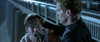 Movie still from “True Lies” (1994), directed by James Cameron – A man holding a gun and another man holding a gun; Close Up shot, Low angle