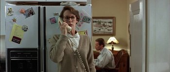 Movie still from “True Lies” (1994), directed by James Cameron – A woman talking on a phone in front of a refrigerator; Medium shot, Low angle
