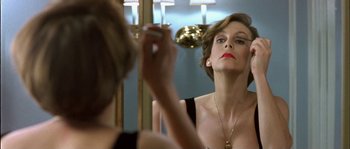 Movie still from “True Lies” (1994), directed by James Cameron – A woman looking in the mirror in front of a bathroom mirror; Close Up shot, Low angle
