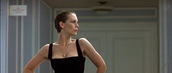 Movie still from “True Lies” (1994), directed by James Cameron – A woman in a black dress is posing for a picture; Close Up shot, Low angle