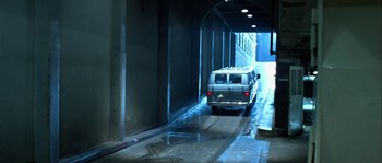 Movie still from “True Lies” (1994), directed by James Cameron – A van is driving through a tunnel on a rainy day; Wide shot, High angle