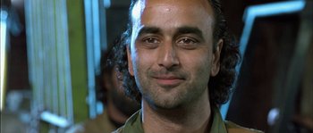 Movie still from “True Lies” (1994), directed by James Cameron – A person wearing a green shirt; Close Up shot, Low angle