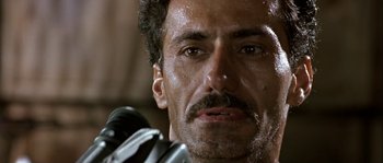 Movie still from “True Lies” (1994), directed by James Cameron – A person with a microphone; Close Up shot, Low angle