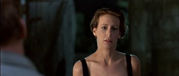 Movie still from “True Lies” (1994), directed by James Cameron – A person with short hair wearing a dress; Close Up shot, Low angle