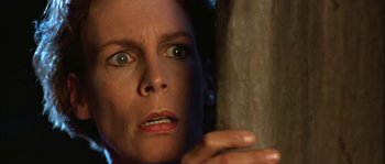 Movie still from “True Lies” (1994), directed by James Cameron – A person holding on to a pole; Close Up shot, Low angle