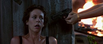 Movie still from “True Lies” (1994), directed by James Cameron – A woman holding a gun up to a man's face; Close Up shot, Low angle