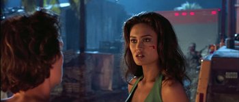 Movie still from “True Lies” (1994), directed by James Cameron – A beautiful woman in a green top standing next to a tree; Close Up shot, Over the shoulder angle