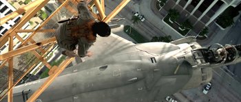Movie still from “True Lies” (1994), directed by James Cameron – A man is climbing up the side of an airplane; Wide shot, Overhead angle