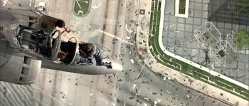 Movie still from “True Lies” (1994), directed by James Cameron – An aerial view of a person standing on the side of an airport runway; Wide shot, Overhead angle