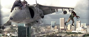 Movie still from “True Lies” (1994), directed by James Cameron – An airplane is flying over a city with buildings in the background; Extreme Wide shot, Low angle