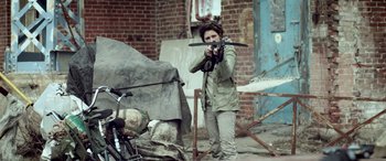Movie still from “Turbo Kid” (2015), directed by Yoann-Karl Whissell – A woman holding a knife in her hand; Medium shot, Over the shoulder angle