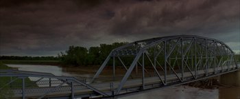 Movie still from “Twister” (1996), directed by Jan de Bont – A metal bridge with a cloudy sky above it; Extreme Wide shot, High angle