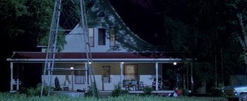 Movie still from “Twister” (1996), directed by Jan de Bont – A white house with a red roof sitting in front of a tree; Extreme Wide shot, Low angle