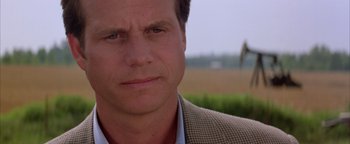 Movie still from “Twister” (1996), directed by Jan de Bont – A person wearing a suit and tie; Close Up shot, Low angle