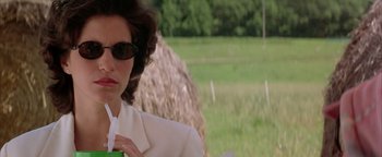 Movie still from “Twister” (1996), directed by Jan de Bont – A woman in a white jacket drinking a green cup; Close Up shot, Over the shoulder angle