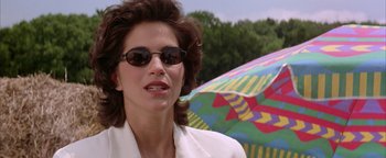 Movie still from “Twister” (1996), directed by Jan de Bont – A person wearing sunglasses and a white jacket; Close Up shot, Low angle