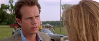 Movie still from “Twister” (1996), directed by Jan de Bont – A man and a woman are standing in front of cars; Close Up shot, Over the shoulder angle