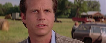 Movie still from “Twister” (1996), directed by Jan de Bont – A person wearing a suit and tie; Close Up shot, Over the shoulder angle