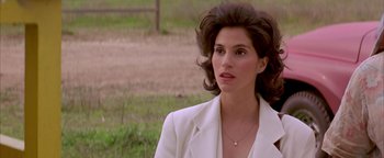 Movie still from “Twister” (1996), directed by Jan de Bont – A woman in a white jacket standing in a field; Close Up shot, Over the shoulder angle