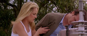 Movie still from “Twister” (1996), directed by Jan de Bont – A beautiful blonde woman holding a man's hat; Medium shot, Over the shoulder angle