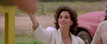 Movie still from “Twister” (1996), directed by Jan de Bont – A woman in a white jacket waving at the camera; Close Up shot, Low angle