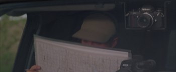 Movie still from “Twister” (1996), directed by Jan de Bont – A man wearing a baseball cap looking out of a window; Close Up shot, Over the shoulder angle