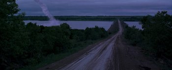Movie still from “Twister” (1996), directed by Jan de Bont – A dirt road near a body of water at night; Extreme Wide shot, High angle
