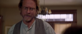 Movie still from “Twister” (1996), directed by Jan de Bont – A person wearing glasses and a vest; Close Up shot, Over the shoulder angle