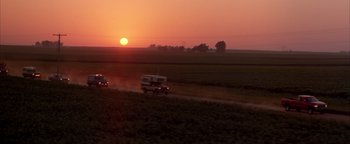 Movie still from “Twister” (1996), directed by Jan de Bont – A truck driving down a dirt road at sunset; Extreme Wide shot, High angle