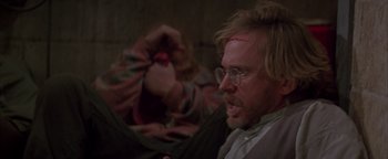 Movie still from “Twister” (1996), directed by Jan de Bont – A man with a bloody head wound is sitting in front of another man with blood on his face; Close Up shot, Over the shoulder angle