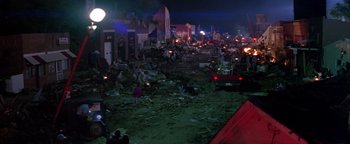 Movie still from “Twister” (1996), directed by Jan de Bont – A city street filled with debris at night time; Extreme Wide shot, High angle