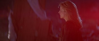 Movie still from “Twister” (1996), directed by Jan de Bont – A woman with blonde hair standing in front of a wall; Medium shot, Low angle